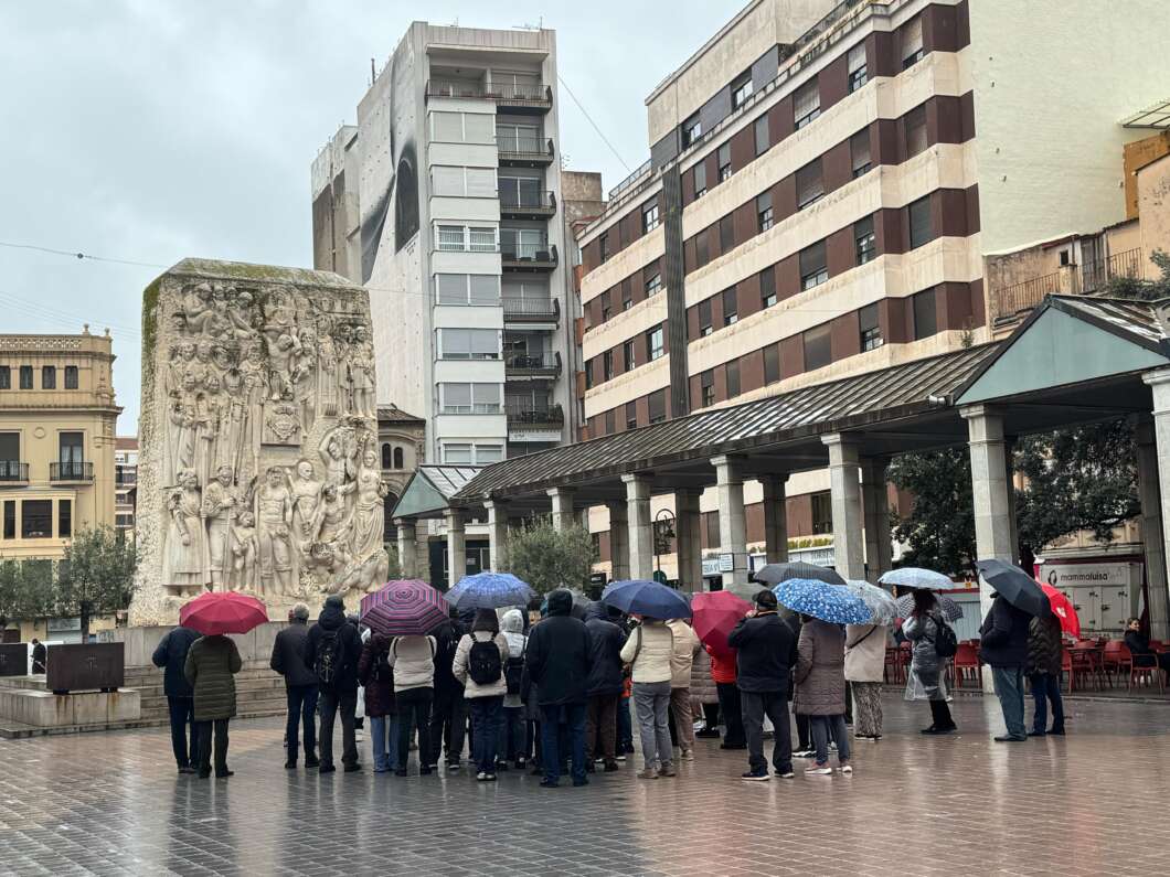 Imagen de una visita guiada en la plaza Santa Clara en una jornada lluviosa.